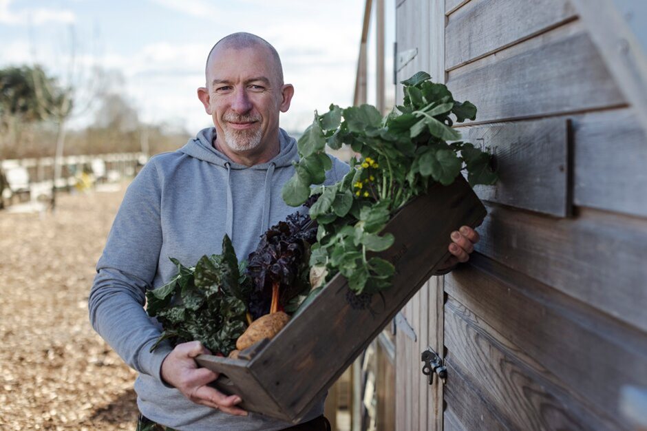 A community allotmenteer holding a tray of produce