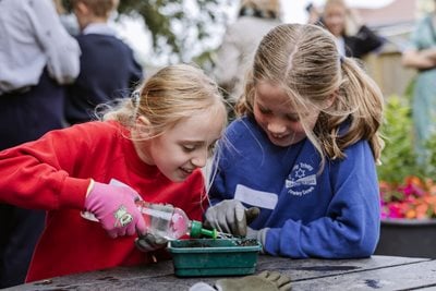 Two pupils watering seedlings