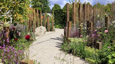 Hidden behind a yew hedge to illustrate life before loss, a meandering gravel pathway represents the many stages of grief; intensifying at its centre before colour returns