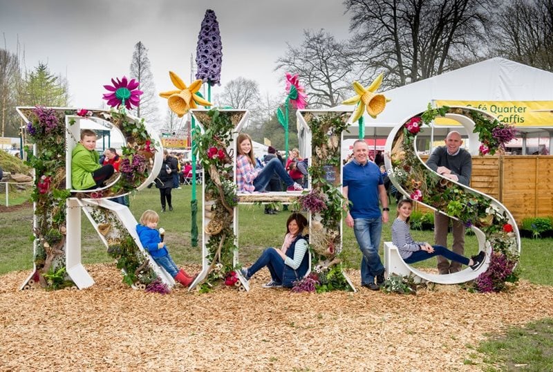 Family sitting in the RHS letters at Cardiff