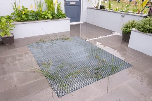 A metal grill with a soakaway underneath to store rainwater