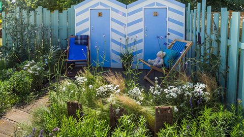 Coastal planting swirls around recycled groyne timbers.