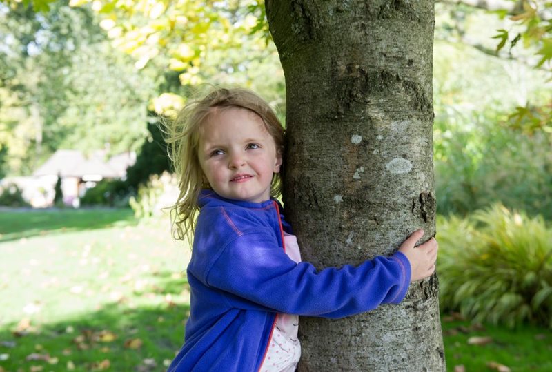 A girl hugs a tree