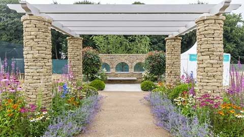 A seating area placed atop paving engraved with words from Tony Walsh's poem, Up 'ere, encourages reflection – while pollinator-friendly planting attracts a touch of the wild side.