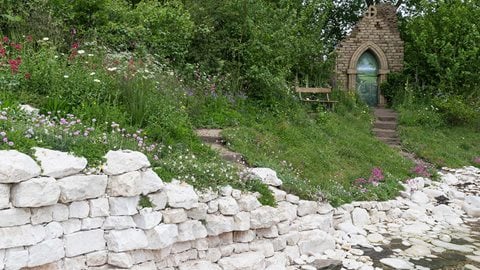 Chalk walling, from a quarry in Flamborough provides the cliff edge support for pale and dark pink thrift and slowly descends to meet steps leading up to the ruined abbey