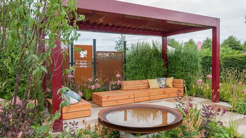 Planting in pink and burnt orange, which incorporates ferns, softens the front and sides of the space.