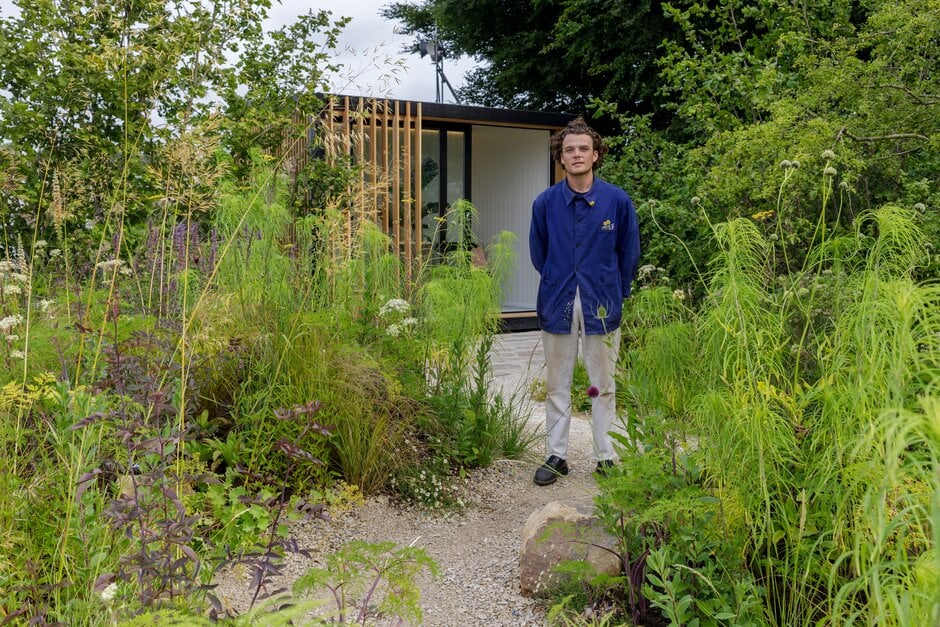 Young designer, Will Scholey, poses with his Working From Home Garden