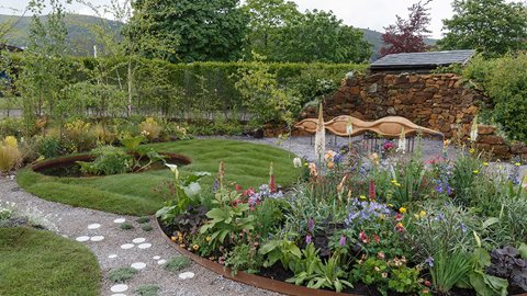 This garden is full of interest, with plenty of detail from woodland planting to stone paving. The wall uses interlocking circles to bring a united feel to the space