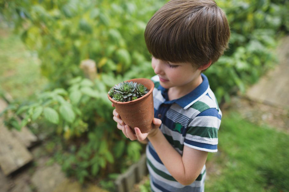 Child holding clay pot