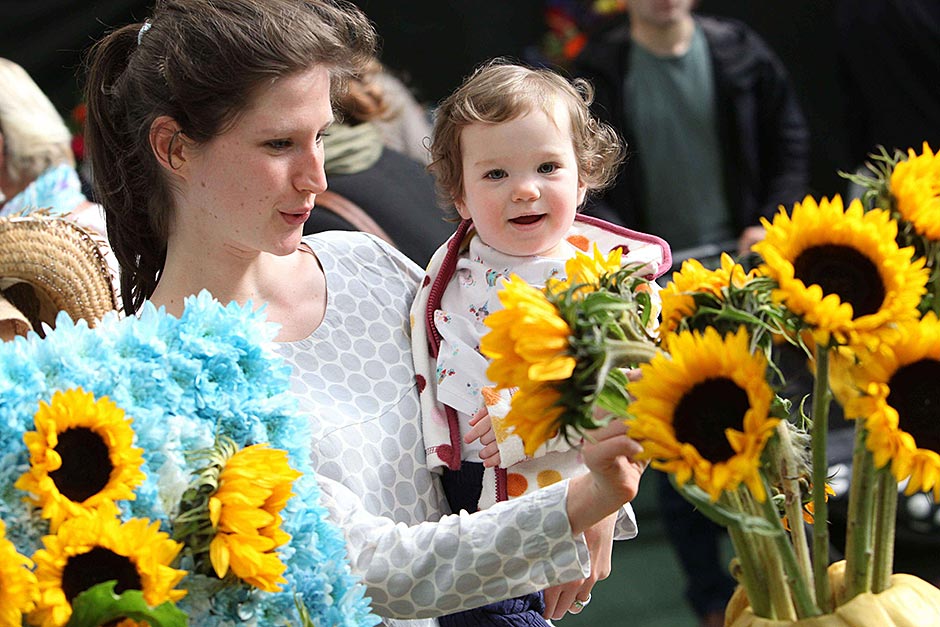 A mum and toddler looking at sunflowers