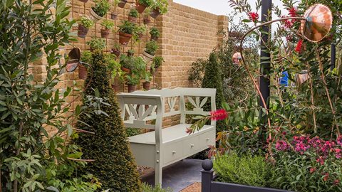 A blend of mixed, herbal planting and copper pipework creates a detailed and beautiful combination