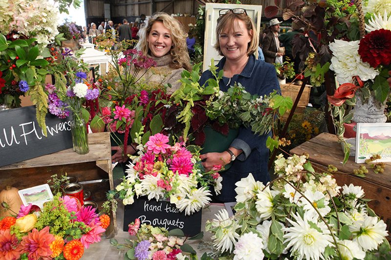 Two women with a hand-tied bouquet display