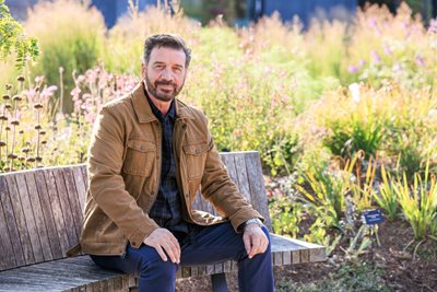 Nick Knowles sitting in garden on bench