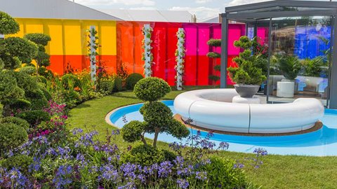 With blocky, plantings including agapanthus and salvias set below cloud pruned Ilex, the area represents the brightly-coloured future, and yet contrasts with the solidity of the past
