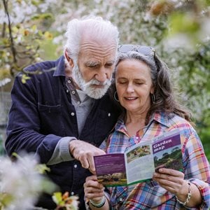 Senior couple looking at a map of an RHS garden