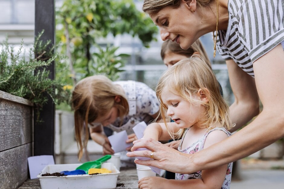 Mother teaching children gardening activities at home