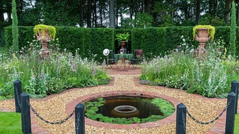 A formal garden inspired by Baroque and Tudor design that cleverly uses shades of terracotta in the handmade brick and landscaping surfaces to unify the space
