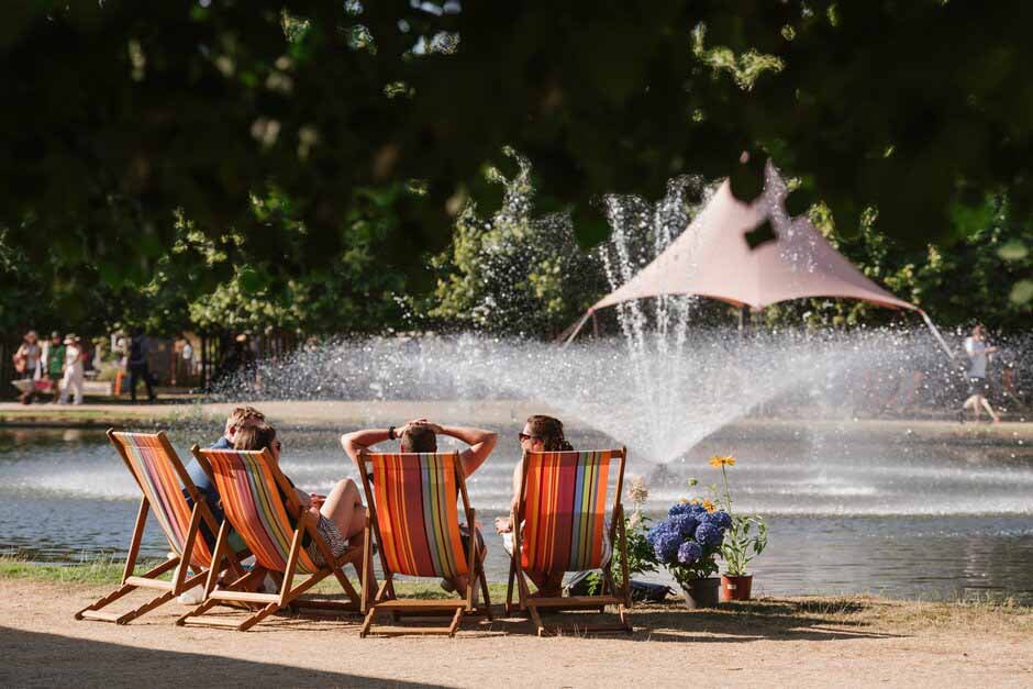 Visitors sit by the Long Water