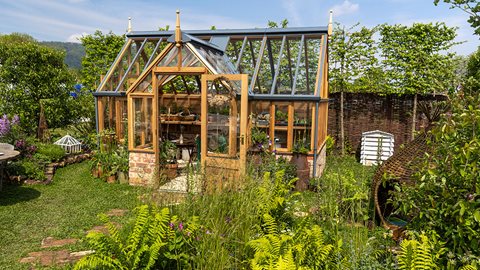 Hidden dens and veg patches are found among the soft plantings of foxgloves, alliums, mint and forget-me-nots, encircling a clover lawn, in this relaxed family garden