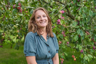 A portrait of Kate Bradbury under a fruiting plum tree