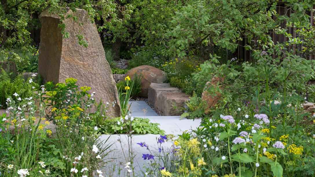 Woodland-edge planting and large rocks lead to a smoother path