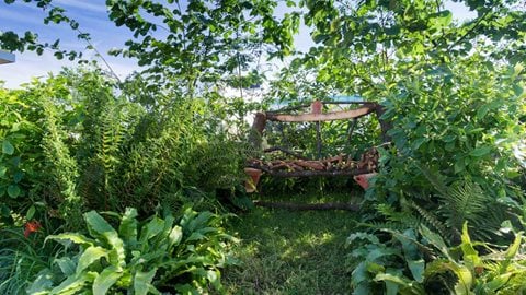Evoking a more intimate and rustic style of gardening with a hand-crafted oak seat surrounded by herbaceous planting