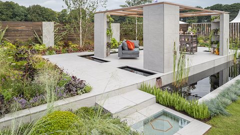 Designed as an entertaining space, this substantial garden uses contemporary outdoor tiles, contrasting foliar colours and moving water to great effect.